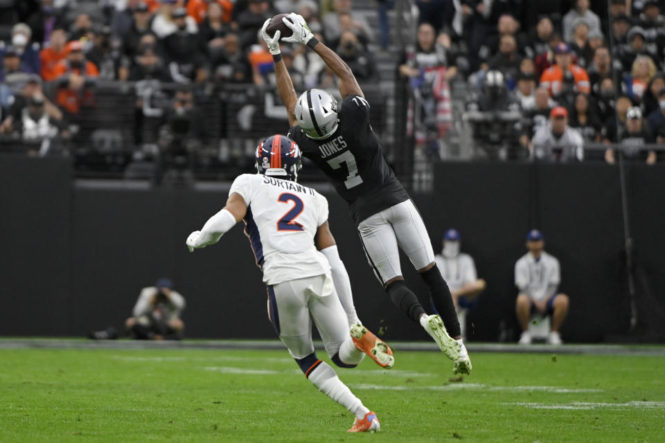 Las Vegas Raiders wide receiver Zay Jones (7) makes a catch against Denver Broncos cornerback Pat Surtain II (2) during the first half of an NFL football game, Sunday, Dec. 26, 2021, in Las Vegas. (AP Photo/David Becker)