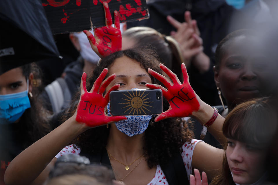 A woman takes a picture during a demonstration in Paris, France, Saturday, June 6, 2020, when protesting against the recent killing of George Floyd, a black man who died in police custody in Minneapolis, U.S.A., after being restrained by police officers on May 25, 2020. Further protests are planned over the weekend in European cities, some defying restrictions imposed by authorities because of the coronavirus pandemic. (AP Photo/Francois Mori)