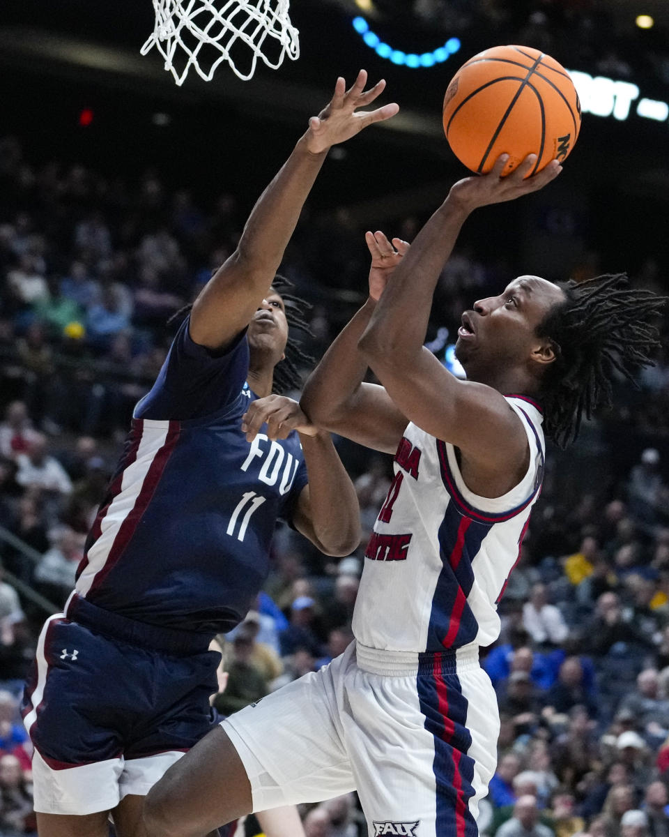 Florida Atlantic guard Michael Forrest (11) shoot over Fairleigh Dickinson forward Sean Moore (11) in the second half of a second-round college basketball game in the men's NCAA Tournament in Columbus, Ohio, Sunday, March 19, 2023. (AP Photo/Michael Conroy)