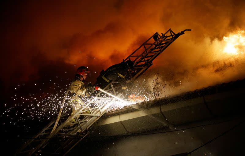 Firefighters extinguish a fire in the university building following a reported shelling in Donetsk