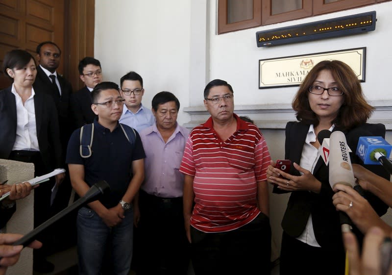 File picture shows lawyer Sangeet Deo (right) speaking to members of the media, accompanied by relatives of passengers Tan Ah Meng, his wife Chuang Hsiu Ling, and son Tan Wei Chew, who were aboard the missing Malaysia Airlines flight MH370. — Reuters pic