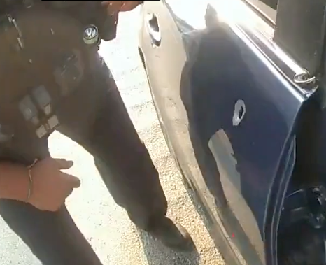 A police officer approaches the bullet-riddled car of George Jensen on May 17 along I-76 in a still image from body camera footage released by the Ohio State Highway Patrol.