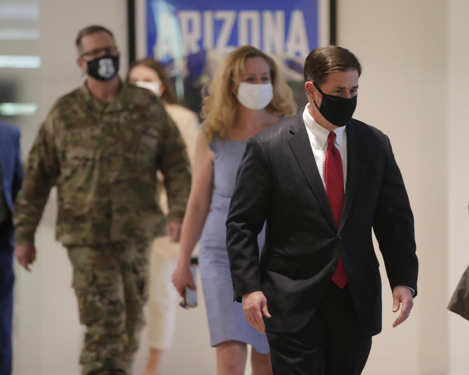 Arizona Gov. Doug Ducey, right, arrives to give an update on COVID-19 in Arizona during a news conference Wednesday, June 17, 2020 in Phoenix. (Michael Chow/The Arizona Republic via AP, Pool)
