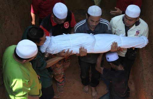 People carry the body of a landslide victim during a funeral in Hulu Langat, Selangor. A close-knit village on the outskirts of the Malaysian capital was grieving for the deaths of 16 people, mostly children, after an orphanage was hit by a devastating landslide