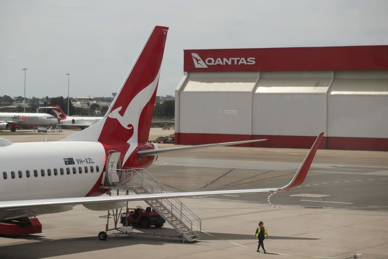 FILE PHOTO: A crew member walks from a Qantas plane at a domestic terminal at Sydney Airport in Sydney