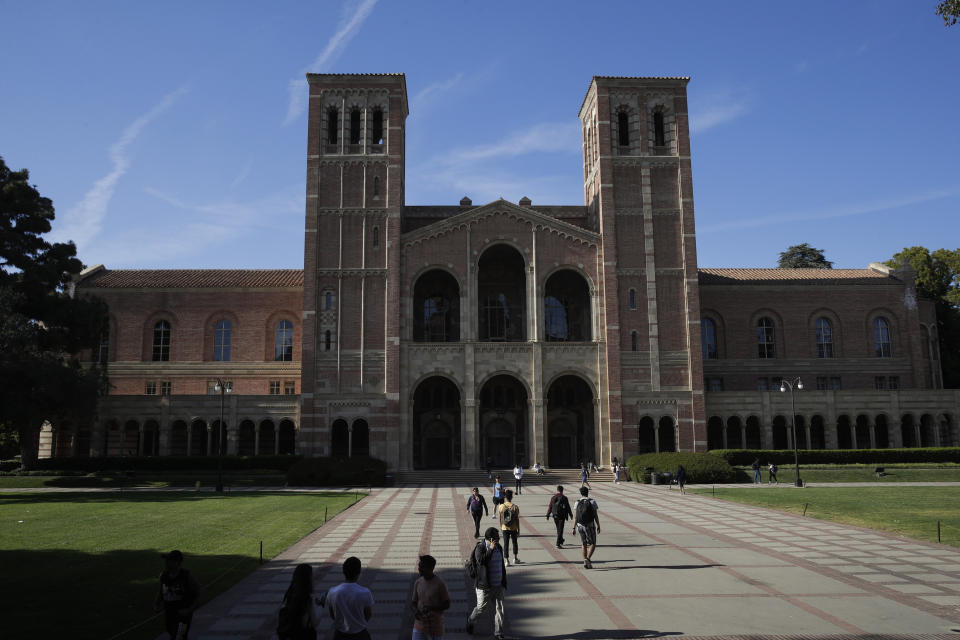 Students walk past Royce Hall at the University of California, Los Angeles Thursday, April 25, 2019, in the Westwood section of Los Angeles. Hundreds of students and staff at two Los Angeles universities, including UCLA, have been placed under quarantine because they may have been exposed to measles. Officials say the people affected by the order either have not been vaccinated or cannot verify that they are immune. (AP Photo/Jae C. Hong)