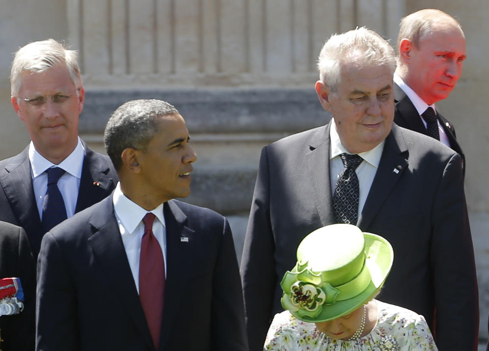 U.S. President Barack Obama watches as Russian President Vladimir Putin walks to his position before a group photo as they take part in the 70th anniversary of D-Day in Benouville in Normandy, France, Friday, June 6, 2014. (AP Photo/Charles Dharapak)