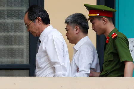 Former Petro Vietnam (PVN) chairman Nguyen Xuan Son (C) is escorted by police to the court for the verdict session in Hanoi, Vietnam September 29, 2017. REUTERS/Kham