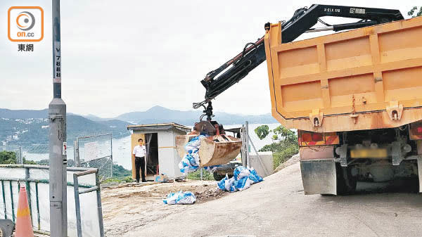 夾斗車將建築廢料夾走。