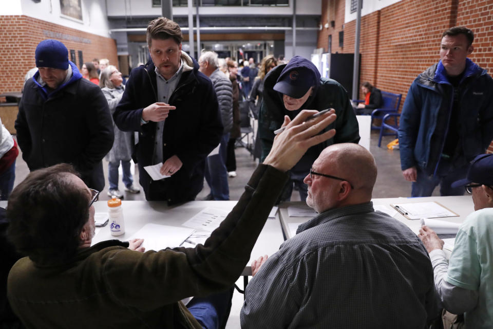 Participantes en un caucus se registran en uno en el centro de educación secundaria Roosevelt, el 3 de febrero de 2020, en Des Moines, Iowa. (AP Foto/Andrew Harnik)