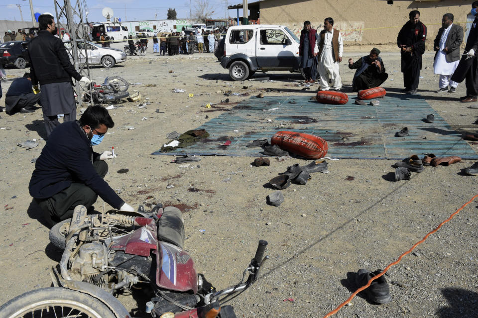 Security officials examine the site of bomb blast in Khanozai, Pashin, a district of Pakistan's Baluchistan province, Wednesday, Feb. 7, 2024. Bombs ripped through two separate political offices in southwestern Pakistan on Wednesday, killing several people and wounding more than two dozen, officials said, the day before the country was set to elect a new parliament. (AP Photo/Asad Ullah)