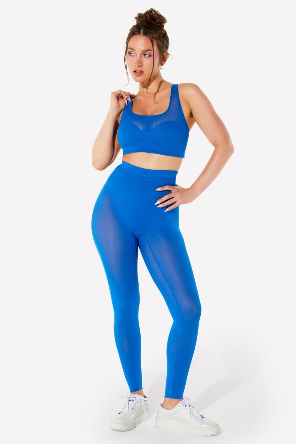 model wearing blue mesh leggings with matching sports bra and white sneakers