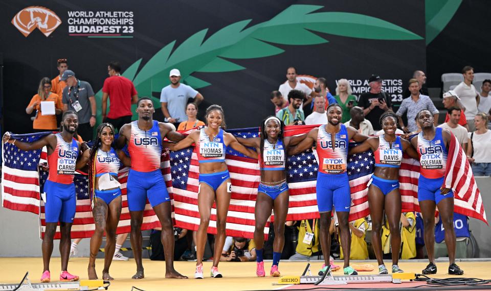 The eight members of the U.S. men's and women's 4x100m relay teams (from left) Brandon Carnes, Sha'Carri Richardson, Fred Kerley, Gabby Thomas, Twanisha Terry, Noah Lyles, Tamari Davis and Christian Coleman celebrate after both won gold at the World Athletics Championships in Budapest, Hungary, on Saturday. (KIRILL KUDRYAVTSEV/AFP via Getty Images)