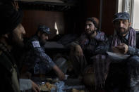 Taliban fighters, some wearing new police uniforms, eat lunch at a police station in Kabul, Afghanistan, Wednesday, Sept. 15, 2021. (AP Photo/Felipe Dana)