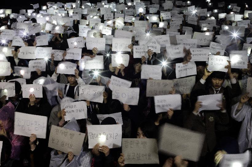 Danwon High School students hold papers with messages such as "come back," "miss you," "love you" and "don't loose your hope" for their friends who are missing after Wednesday's ferry disaster at the school yard in Ansan, South Korea, Thursday, April 17, 2014. Strong currents, rain and bad visibility hampered an increasingly anxious search Thursday for 287 passengers, many thought to be high school students, still missing more than a day after their ferry flipped onto its side and sank in cold waters off the southern coast of South Korea. (AP Photo/Woohae Cho)