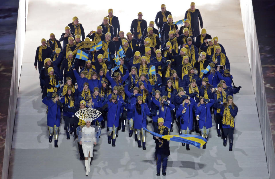 Anders Soedergren of Sweden holds his national flag and enters the arena with teammates during the opening ceremony of the 2014 Winter Olympics in Sochi, Russia, Friday, Feb. 7, 2014. (AP Photo/Charlie Riedel)