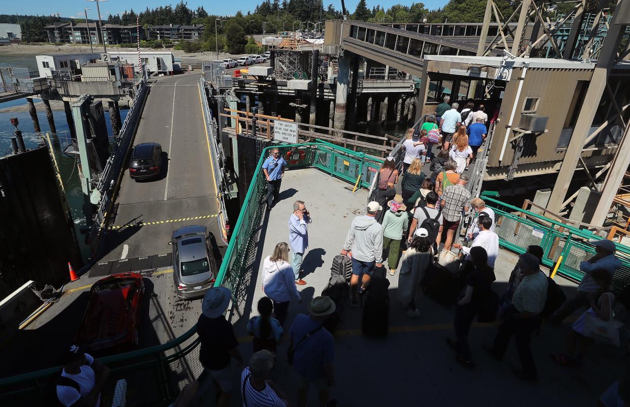 Passengers head for the walkway off the Washington State Ferries vessel Tacoma at the Bainbridge Island ferry terminal on Aug. 3.