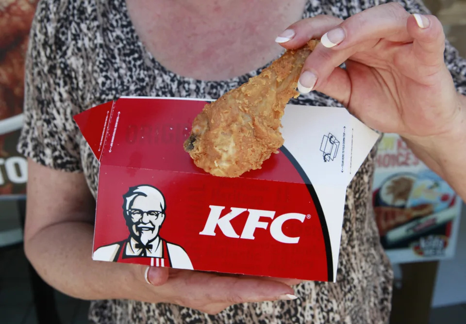 A customer hold a piece of Kentucky Fried Chicken outside a KFC restaurant, Tuesday, July 13, 2010, in Mountain View, Calif. Yum Brands Inc., which owns Taco Bell, Pizza Hut and KFC, reports second-quarter results after the close of regular trading. (AP Photo/Paul Sakuma)