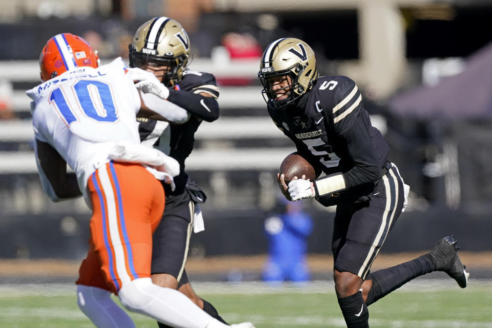 Vanderbilt quarterback Mike Wright (5) scrambles around Florida safety Miguel Mitchell (10) in the first half of an NCAA college football game Saturday, Nov. 19, 2022, in Nashville, Tenn. (AP Photo/Mark Humphrey)