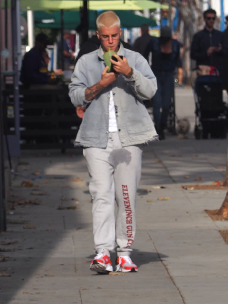 Justin Bieber walks on the street in sweatpants with a water stain below his crotch.