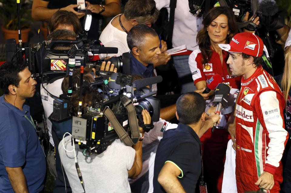 Ferrari Formula One driver Fernando Alonso of Spain is interviewed after the qualifying session of the Singapore F1 Grand Prix at the Marina Bay street circuit in Singapore September 21, 2013. REUTERS/Tim Chong (SINGAPORE - Tags: SPORT MOTORSPORT F1)