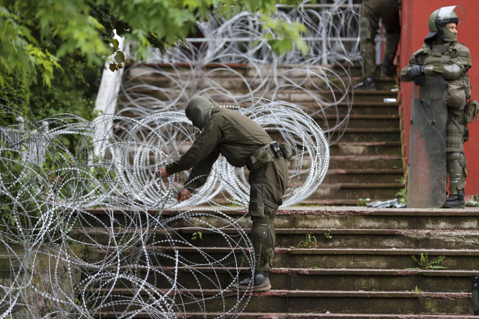 KFOR soldiers place a barbed wire in front of the city hall in the town of Zvecan, northern Kosovo, Wednesday, May 31, 2023. Hundreds of ethnic Serbs began gathering in front of the city hall in their repeated efforts to take over the offices of one of the municipalities where ethnic Albanian mayors took up their posts last week. (AP Photo/Bojan Slavkovic)
