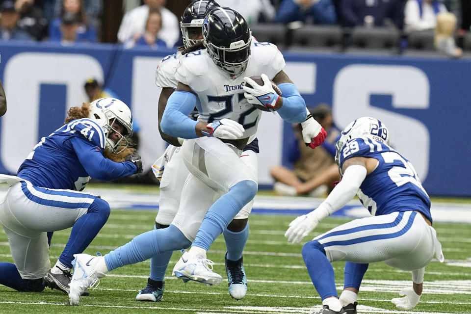 Tennessee Titans running back Derrick Henry (22) runs the ball past Indianapolis Colts linebacker Grant Stuard, left, and cornerback JuJu Brents, right, during the first half of an NFL football game, Sunday, Oct. 8, 2023, in Indianapolis. (AP Photo/Darron Cummings)