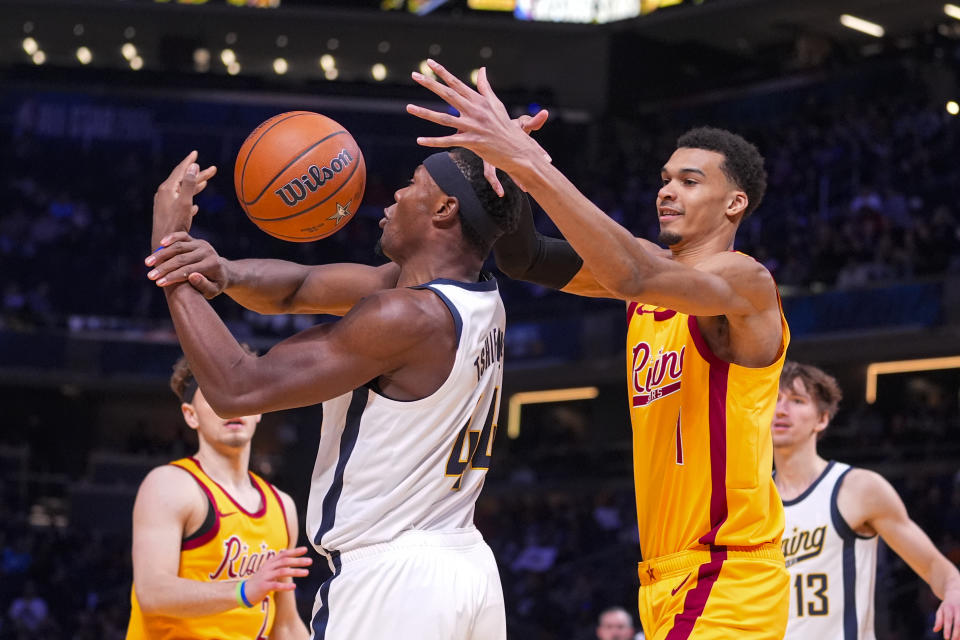 Victor Wembanyama, center right, of the San Antonio Spurs, stops a shot by Oscar Tshiebwe, center left, of the Indiana Mad Ants, during an NBA Rising Stars basketball game in Indianapolis, Friday, Feb. 16, 2024. (AP Photo/Michael Conroy)