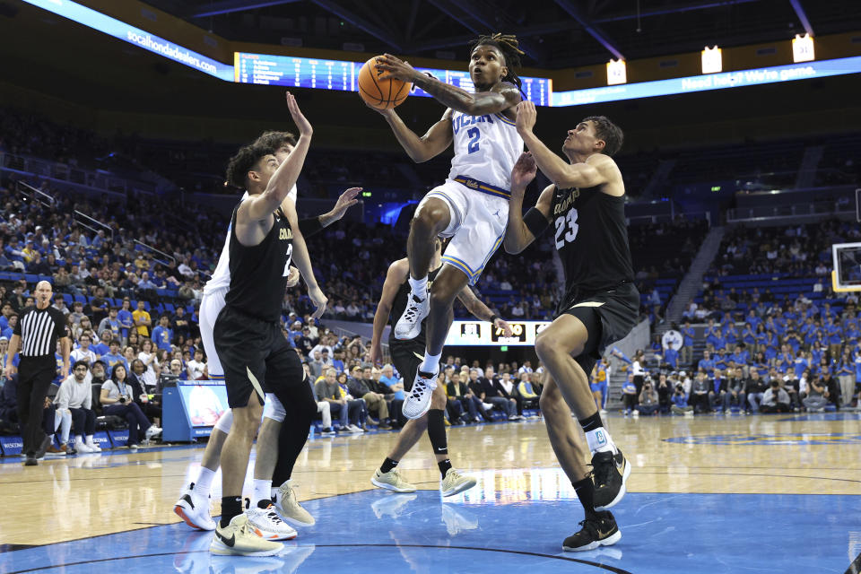 UCLA guard Dylan Andrews (2) lays up the ball while defended by Colorado guard KJ Simpson, left, and forward Tristan da Silva (23) during the second half of an NCAA college basketball game Thursday, Feb. 15, 2024, in Los Angeles. (AP Photo/Raul Romero Jr.)