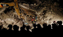 Rescuers work in the night at a collapsed house following an earthquake in Pescara del Tronto, central Italy, August 24, 2016. REUTERS/Remo Casilli