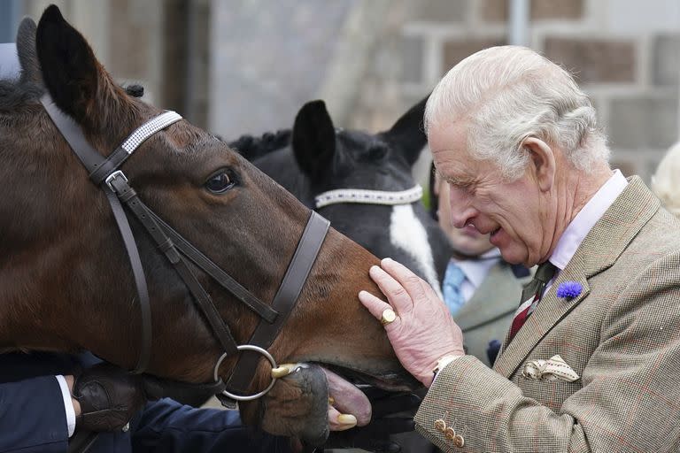 El rey Carlos III da una zanahoria a un caballo durante un evento en Ballater, Gran Bretaña, el martes 11 de octubre de 2022.