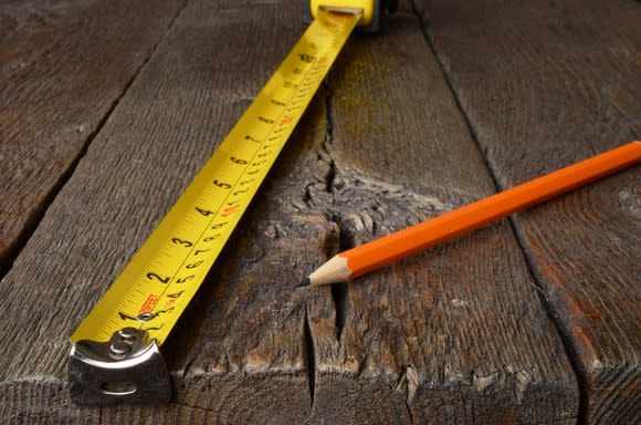 A tape measure and pencil on a wooden table