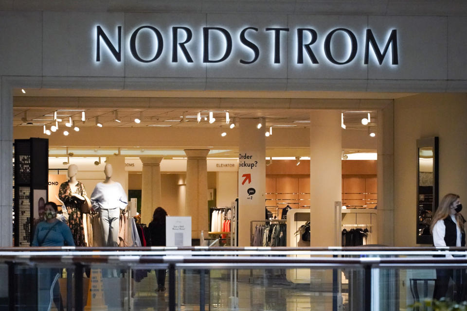 Shoppers walk near an entrance to a Nordstrom store at a shopping mall in Pittsburgh on Wednesday, Feb. 24, 2021.  Nordstrom says it's acquiring a minority interest in four fashion brands owned by a British company called Asos as the department store aims to reach out to younger customers. The brand - Topshop, Topman, Miss Selfridge and HIIT - were purchased by Asos in February after their previous owner and British fashion empire Arcadia Group filed for bankruptcy in late 2020.  (AP Photo/Keith Srakocic)