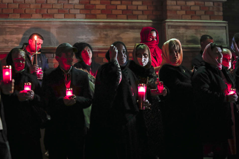 Orthodox worshipers, a few wearing masks for protection against the COVID-19 virus, attend a religious service in the Black Sea port of Constanta, Romania, Wednesday, May 27, 2020. Wanting to give worshippers the opportunity to take part in what is considered to be the most important Christian celebration, Romanian Orthodox Archbishop Teodosie held an unprecedented Easter service Tuesday night that continued into the early hours of Wednesday. (AP Photo/Vadim Ghirda)