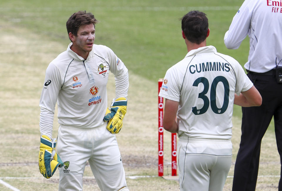 Australian captain Tim Paine, left, talks with bowler Pat Cummins during play on day three of the fourth cricket test between India and Australia at the Gabba, Brisbane, Australia, Sunday, Jan. 17, 2021. (AP Photo/Tertius Pickard)