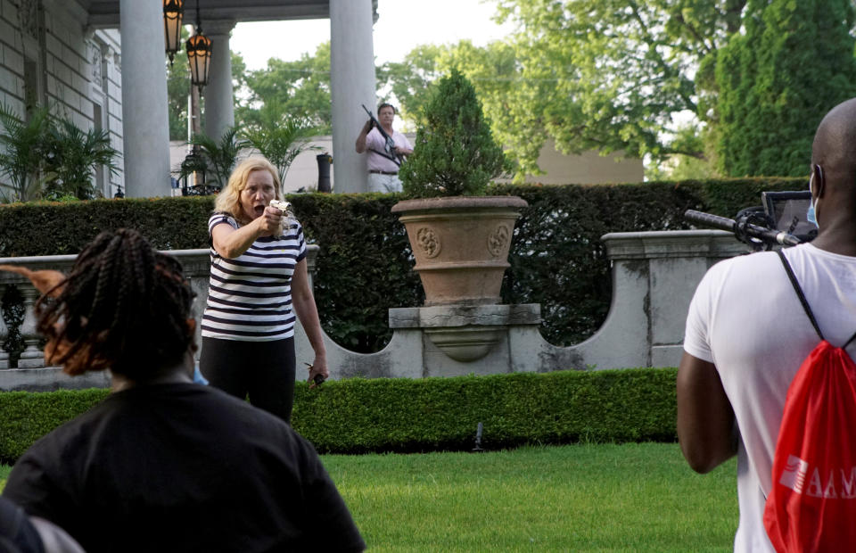 Image: A couple draws guns at protesters in St. Louis on June 28, 2020. (Lawrence Bryant / Reuters file)