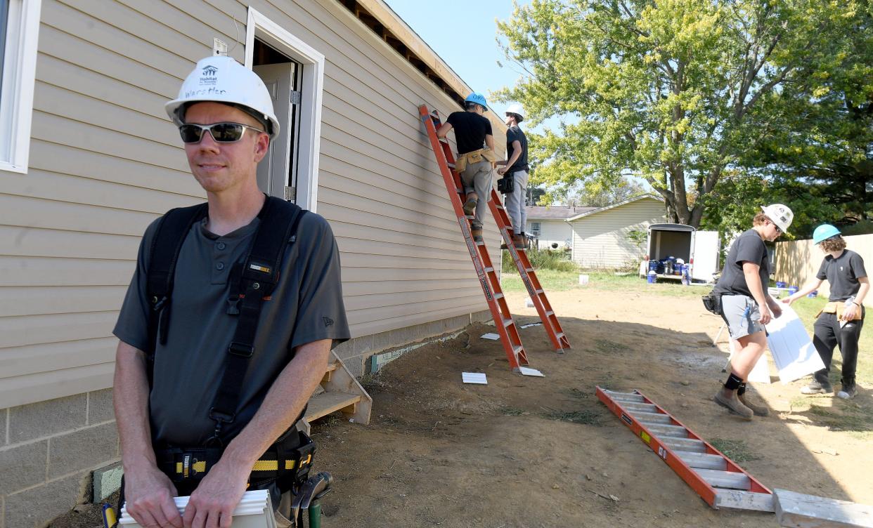 Washington High School construction trades teacher Jason Werstler works with students at a Habitat for Humanity house in Massillon in October.