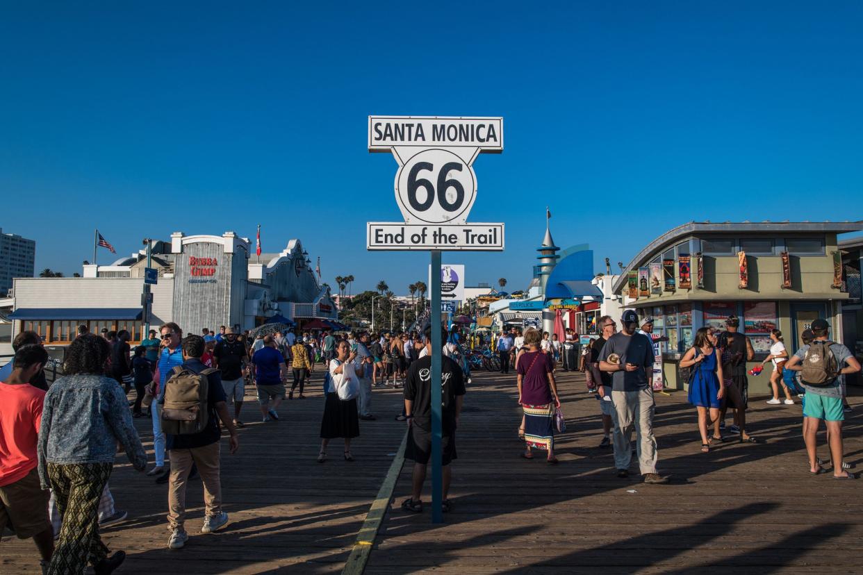 end of route 66 sign with pier in background