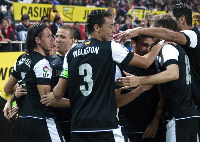 Malaga's Martin Demichelis (L) celebrates with teammates after scoring a goal against Sevilla during their Spanish La Liga match at the Ramon Sanchez Pizjuan stadium in Sevilla, on December 15, 2012. Malaga won 2-0