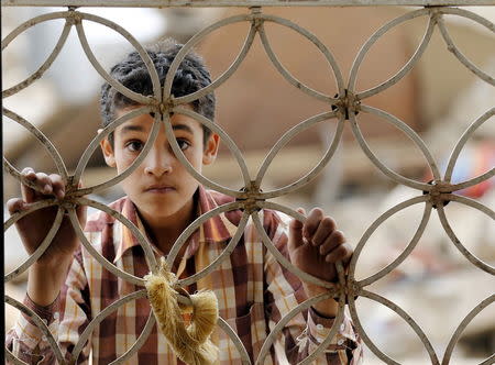 A boy looks through the window grills of a house that was damaged by a Saudi-led air strike in Yemen's capital Sanaa August 26, 2015. REUTERS/Khaled Abdullah