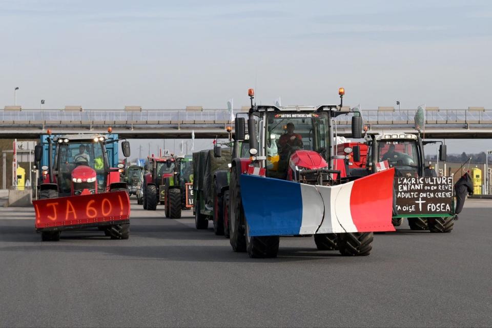 Farmers drive their tractors on a motorway north of Paris on Monday (AP)