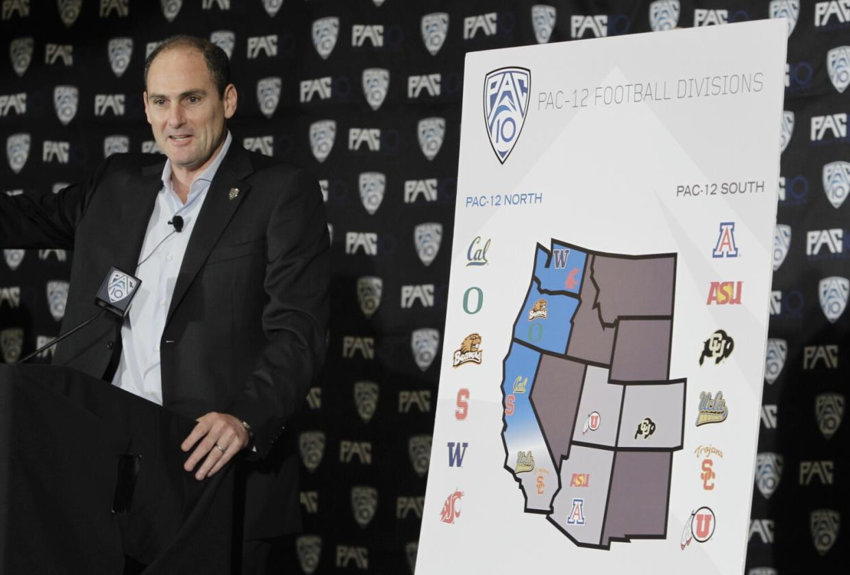 Pac-10 commissioner Larry Scott stands next to a chart as he announces the splitting of NCAA college football divisions