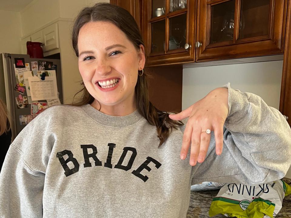 A side-by-side of a woman wearing a bride sweatshirt holds up her hand with an engagement ring on it.