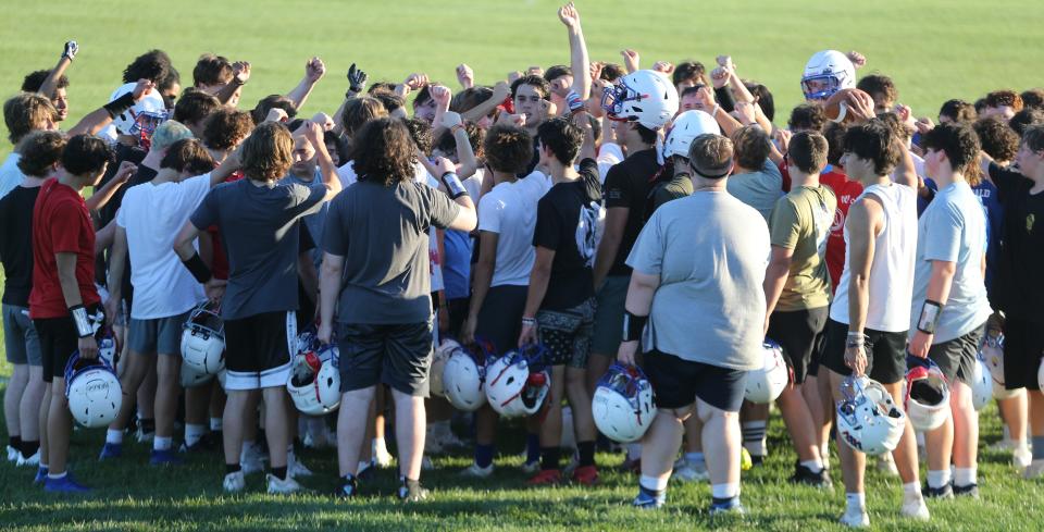 The Winnacunnet High School football team huddles during the first day of practice Friday, Aug. 11, 2023.