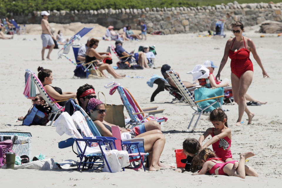 Beachgoers relax on the shore at Good Harbor Beach in Gloucester, Mass., Friday, May 22, 2020. Beaches in Gloucester reopened with restrictions on Friday after being closed two months ago due to the pandemic. (AP Photo/Charles Krupa)