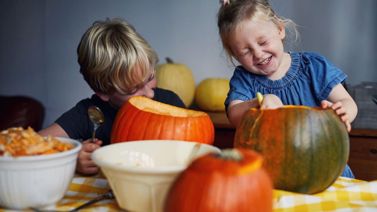  Halloween jokes illustrated by laughing children carving pumpkins. 