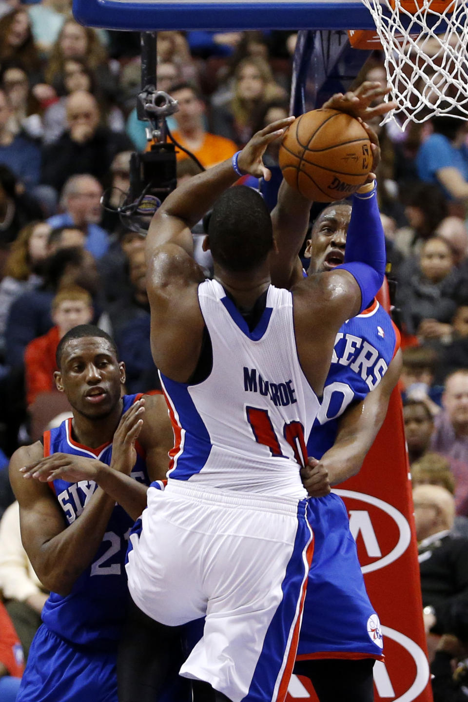 Detroit Pistons' Greg Monroe, center, tries to shoot past Philadelphia 76ers' Jarvis Varnado, right, and Thaddeus Young during the first half of an NBA basketball game on Saturday, March 29, 2014, in Philadelphia. (AP Photo/Matt Slocum)