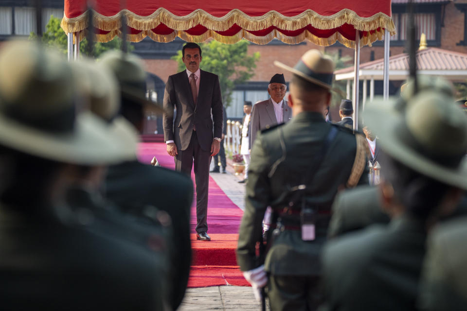 Qatar's Emir Sheikh Tamim bin Hamad Al Thani, center left, stands with Nepal's President Ram Chandra Poudel, center right as he receives guard of honor at his arrival at the airport in Kathmandu, Nepal, Tuesday, April 23, 2024. The emir is on a two-days visit to the Himalayan nation. (AP Photo/Niranjan Shreshta)