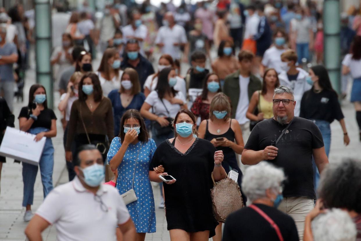 People wearing protective masks walk in a street in Nantes as France: REUTERS/Stephane Mahe