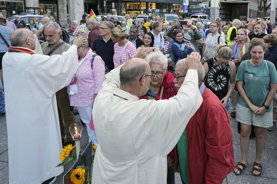 Married and same-sex couples take part in a public blessing ceremony in front of the Cologne Cathedral in Cologne, Germany, Wednesday, Sept. 20, 2023. Several Catholic priests held a ceremony blessing same-sex and also re-married couples outside Cologne Cathedral in a protest against the city's conservative archbishop, Cardinal Rainer Maria Woelki. (AP Photo/Martin Meissner)